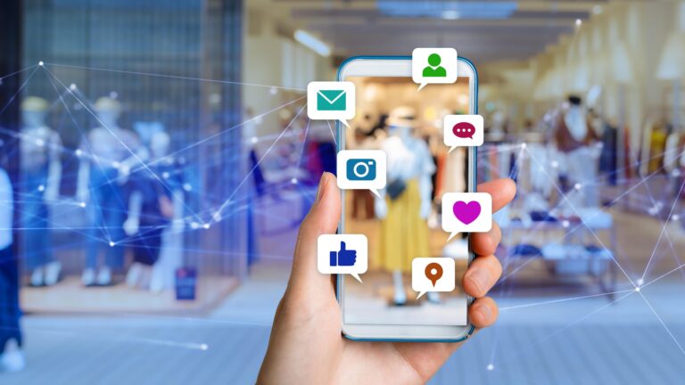 Bir el, sosyal medya ikonları olan bir akıllı telefonu tutuyor
