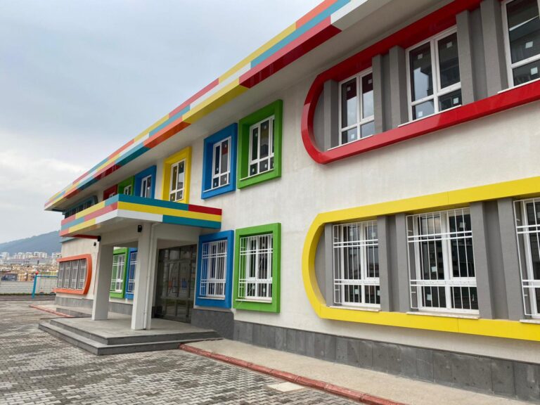 Renkli çerçeveli pencereleri olan modern bir okul binası