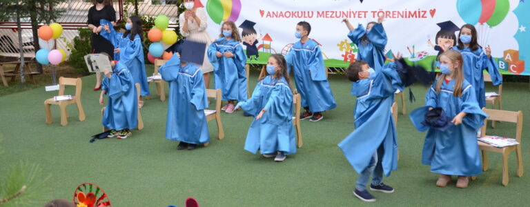 Çocuklar mezuniyet töreninde mavi cübbelerle dans ediyor